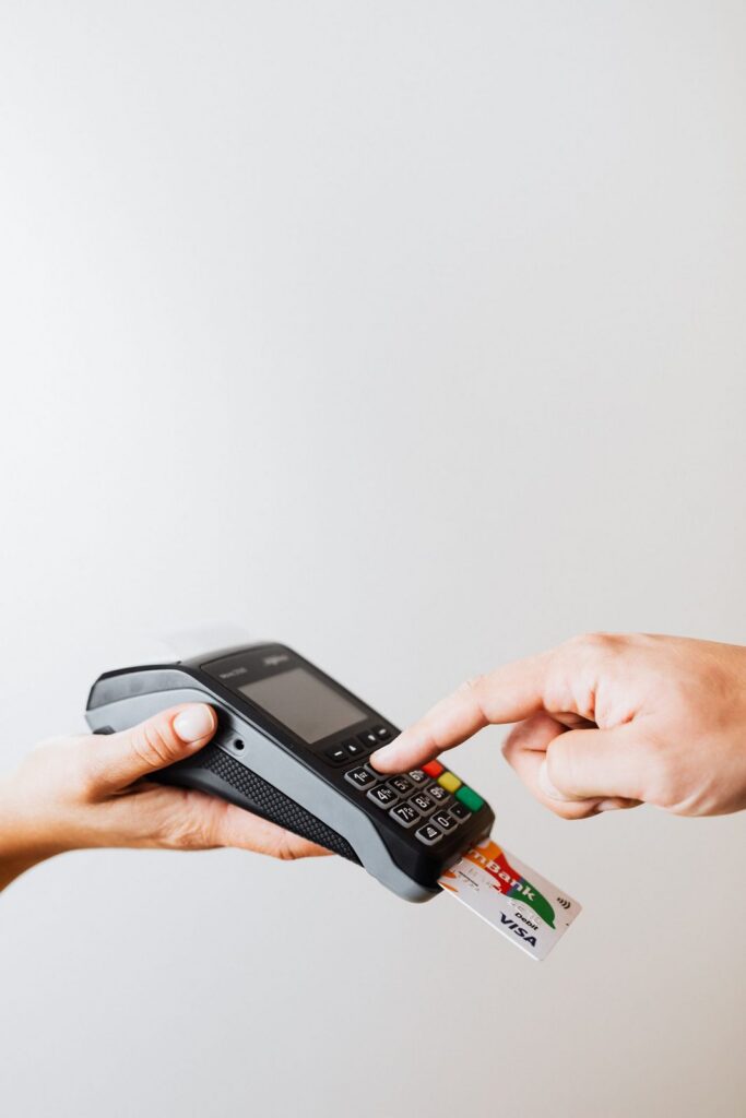Hand holding a card to a payment terminal