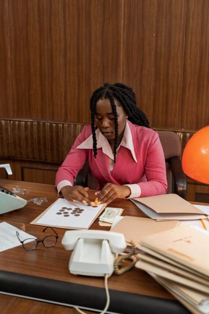 Woman counting coins and notes at her desk
