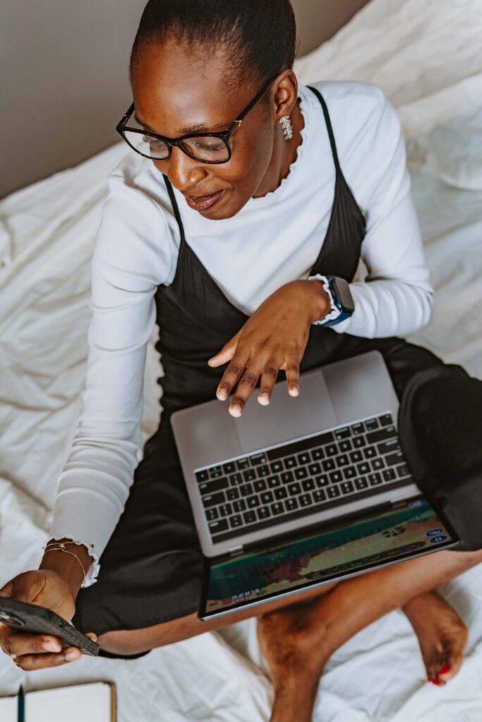 Woman using a laptop and a phone at home