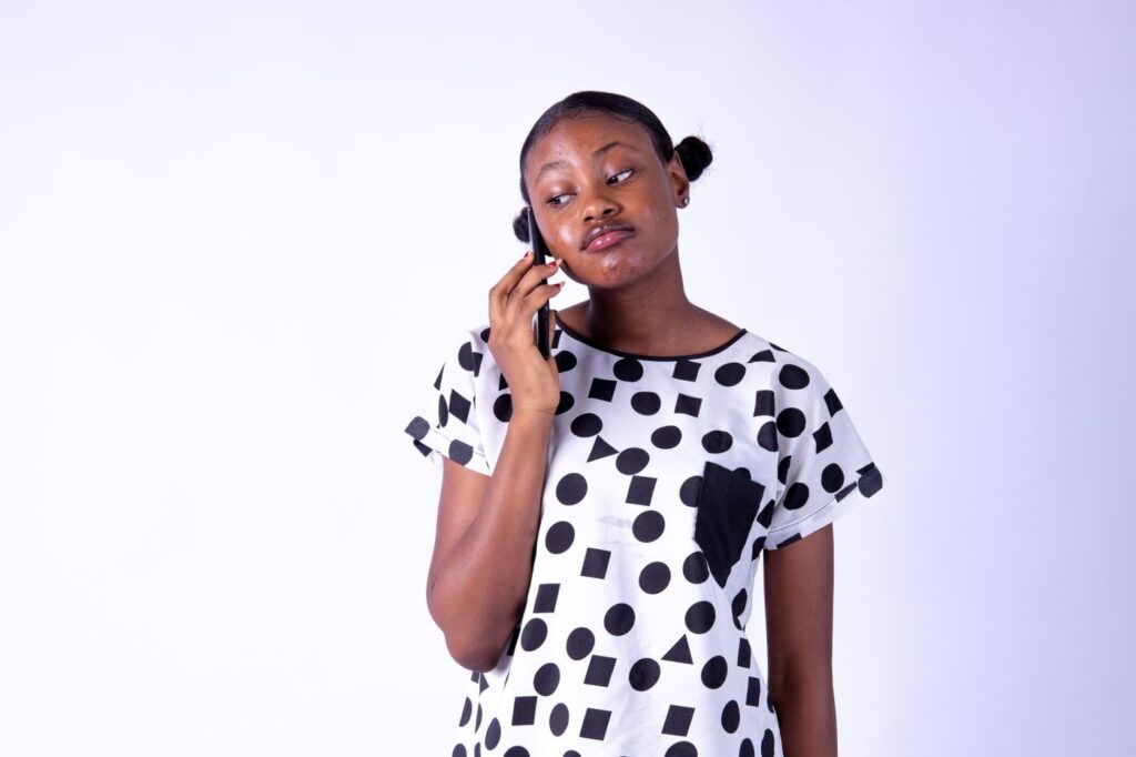 Woman in a polka dot top talking on her phone